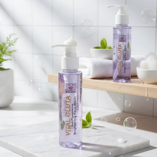 Two bottles of Vital Gluta Brightening Face Wash arranged on a marble tray and shelf in a bright bathroom setting with tiled walls, soap dishes, and floating bubble graphic 